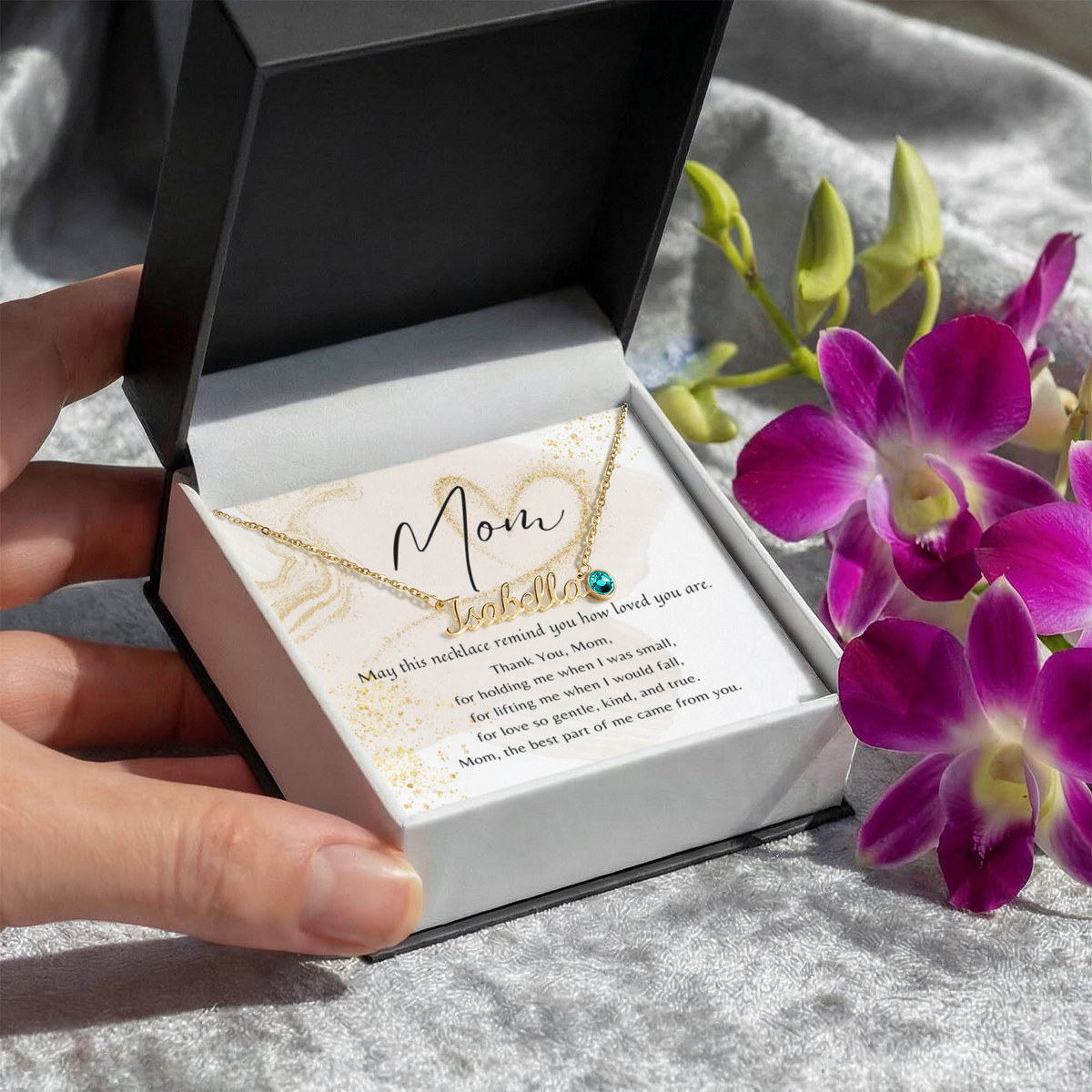 Custom Name Necklace with Birthstone for Mom – A Meaningful Gift of Love | gold necklace in gift box with heartfelt poem card and flowers nearby