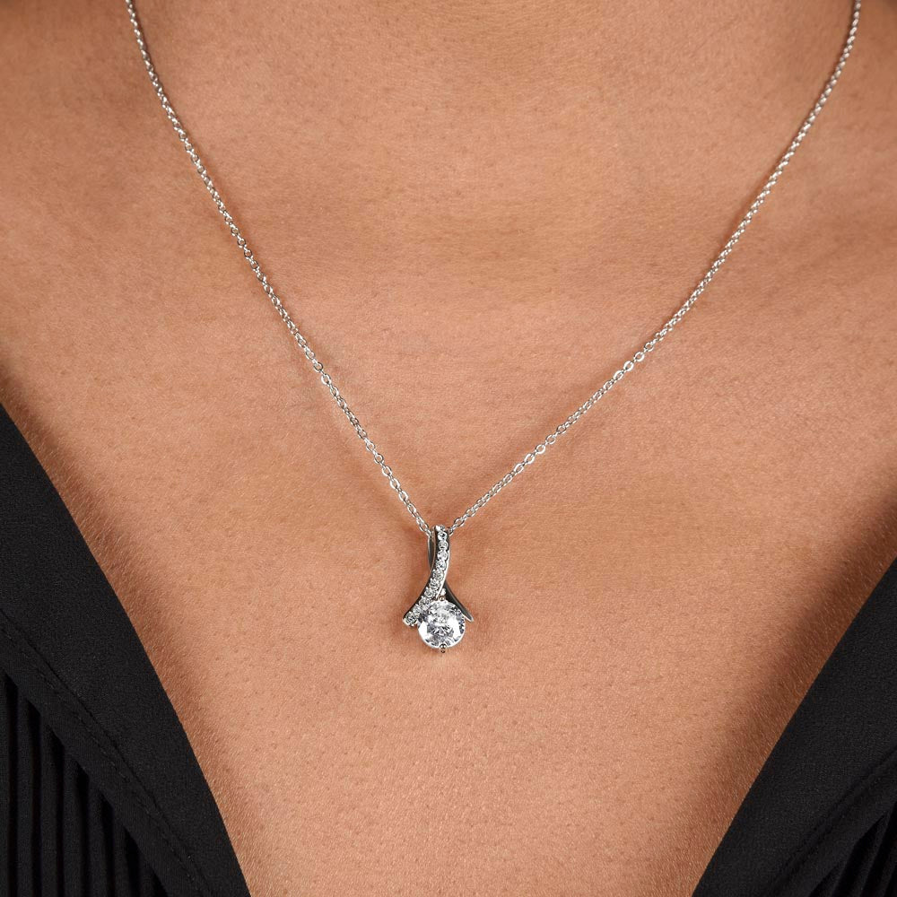Delicate ribbon-shaped necklace pendant with sparkling cubic zirconia on a 14k white gold plated chain.