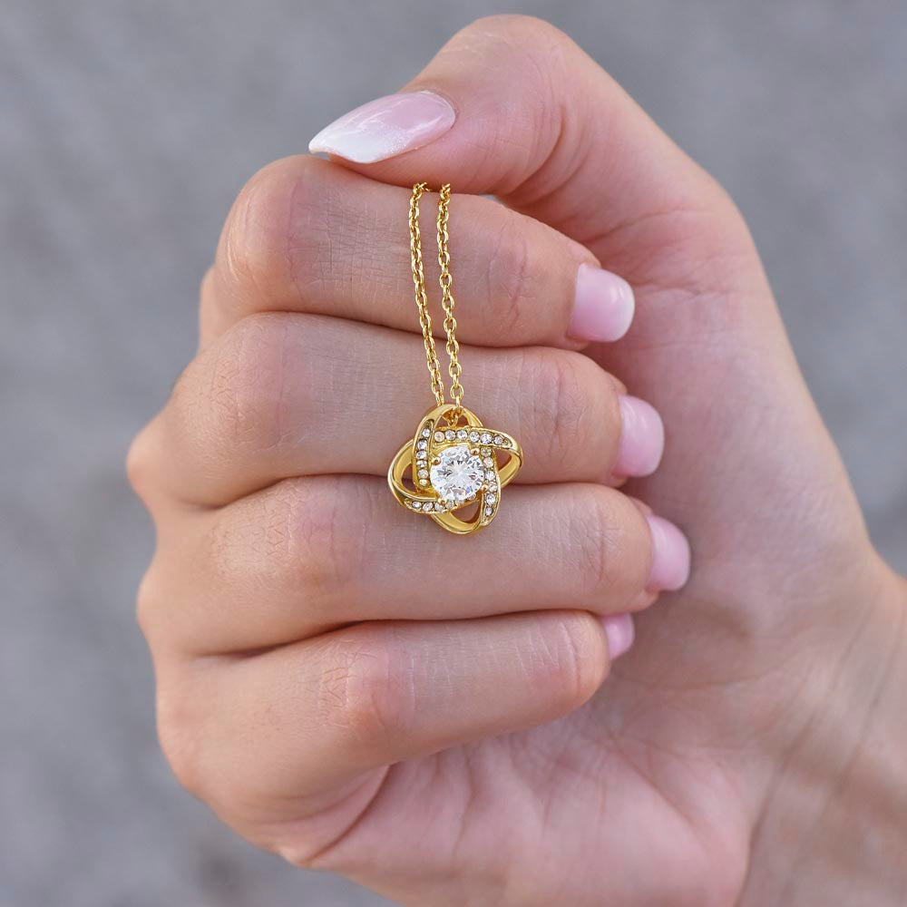 Love Knot Necklace for Sister – 14k White Gold or 18k Yellow Gold Plated showing elegant gold pendant held gently in hand