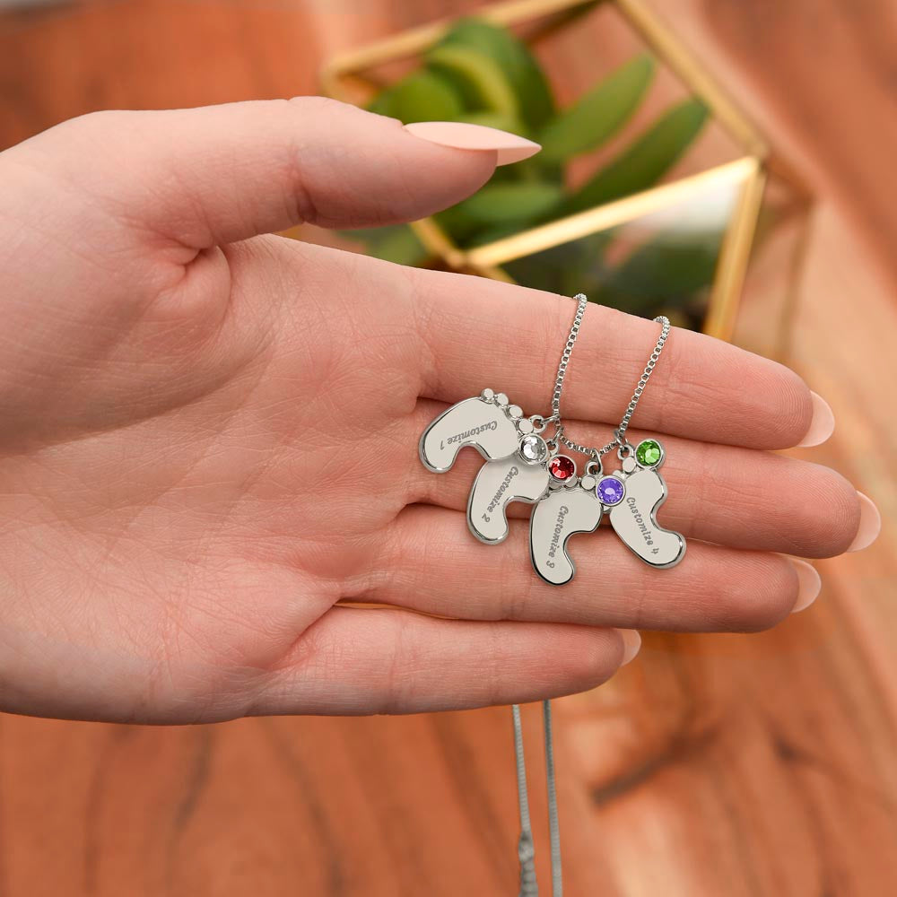 Personalized Engraved Baby Feet Necklace with Birthstone for Mom – A Meaningful Gift of Love | silver finish with colorful stones on chain held in hand