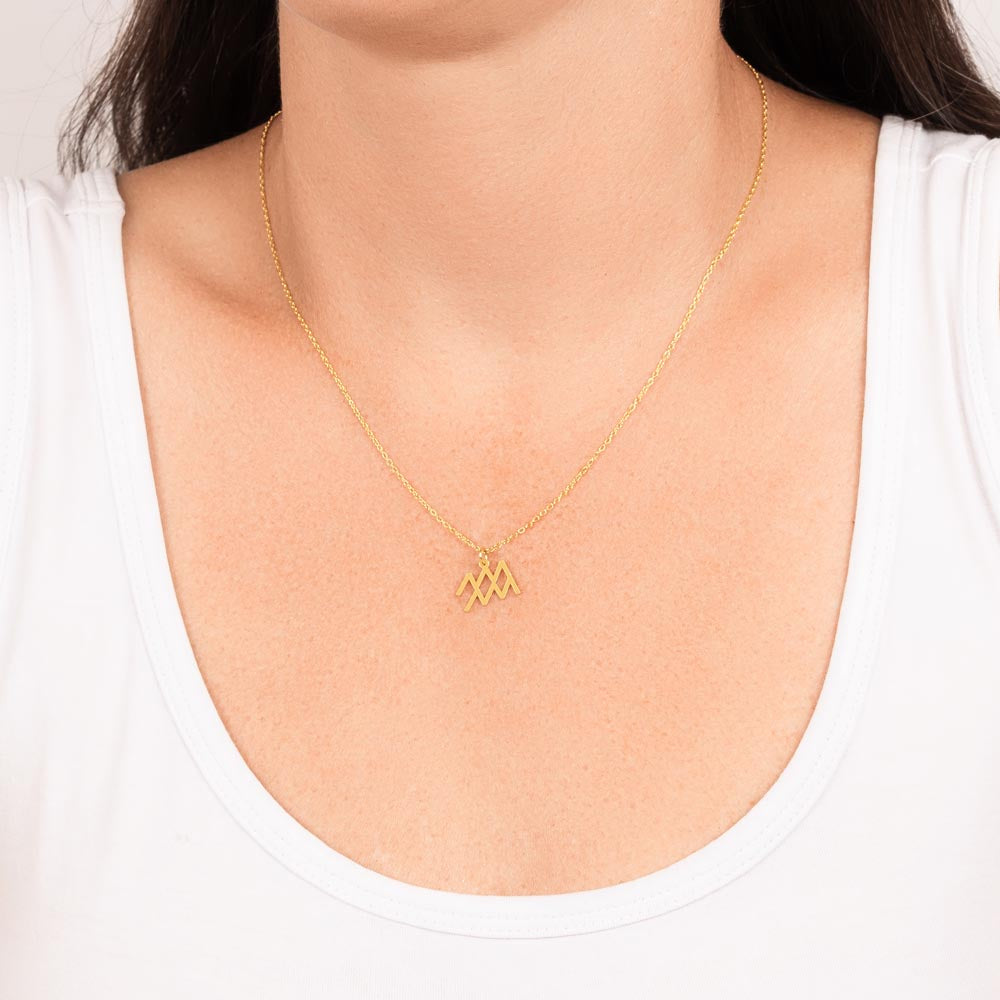 Aquarius Zodiac Necklace for Women – Astrology Gift shown as gold pendant on delicate chain worn with white top