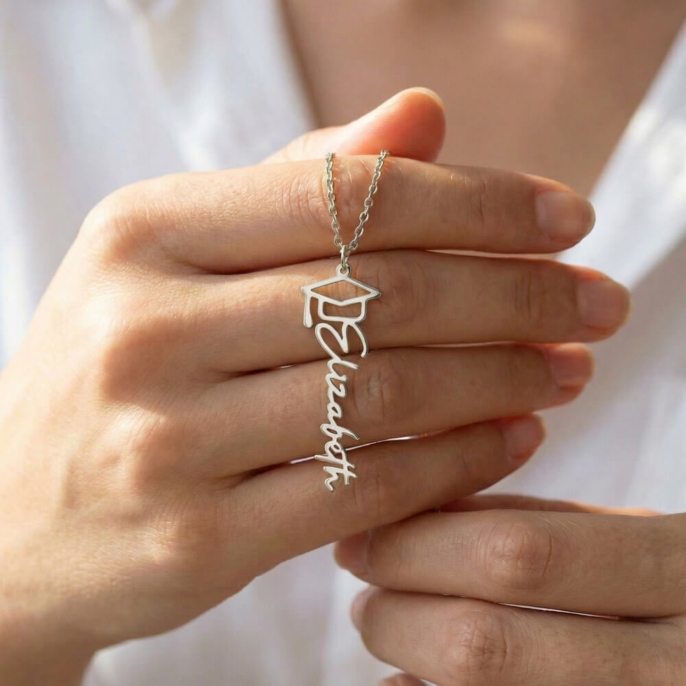 Custom Graduation Cap Name Necklace for Graduate – Personalized Graduation Gift with silver name and cap charm held in hand